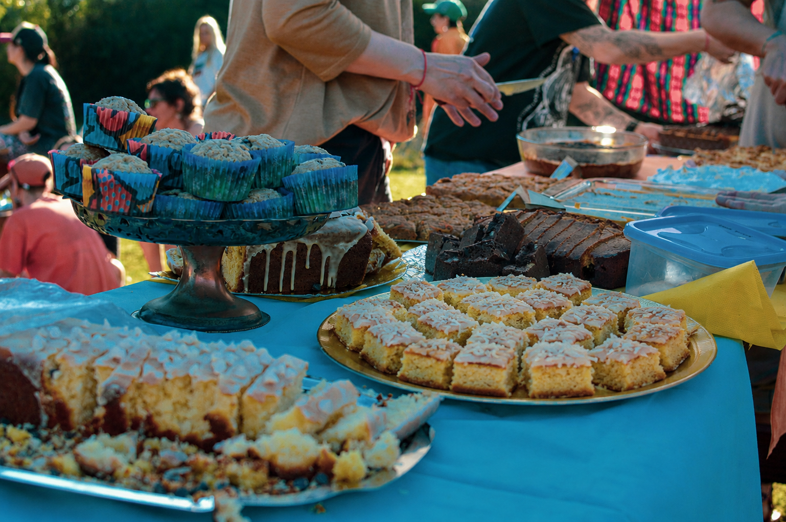 Mesa comunitaria con tortas y cosas dulces durante Sincro Nube